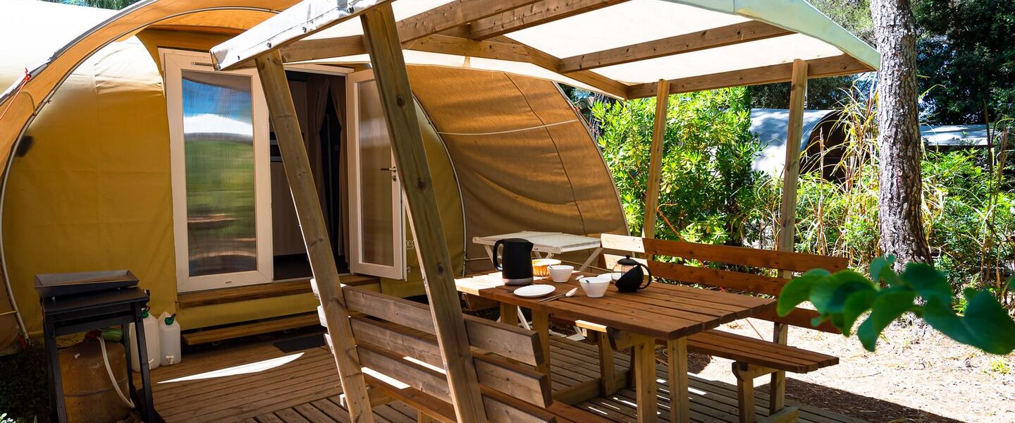 Ein bereits aufgestelltes und perfekt eingerichtetes Zelt auf einem Campingplatz am Mittelmeer